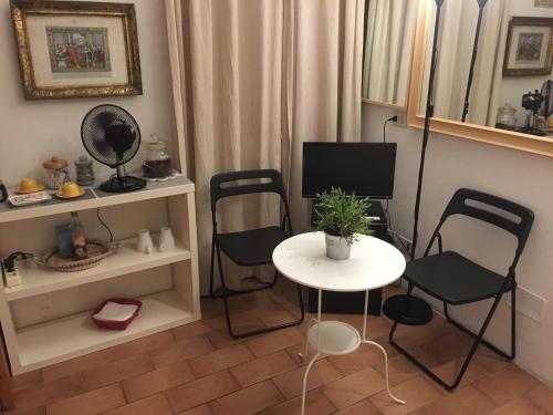 ローマにあるSmall Navona Studioのテーブルと椅子、テレビが備わる客室です。