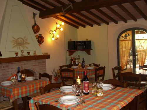 a dining room with two tables and a fireplace at La Casanuova in Lajatico