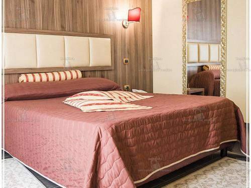 a bedroom with a large bed with a red blanket at Hotel Bellavista in Marina di Varcaturo