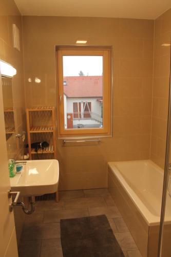 a bathroom with a tub and a sink and a window at Ferienhaus in Jois in Jois