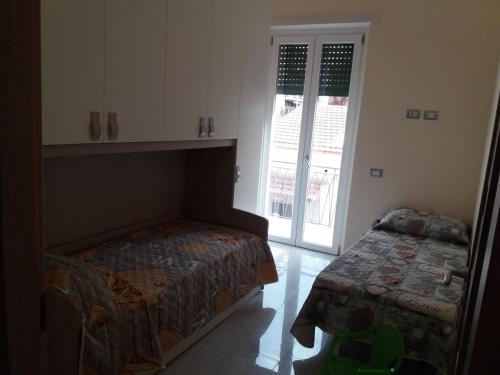 a bedroom with a bed and a table and a window at La Casa Del Fornaio in Ciampino