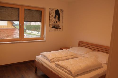 łóżko w sypialni z oknem w obiekcie Ferienhaus in Jois w mieście Jois