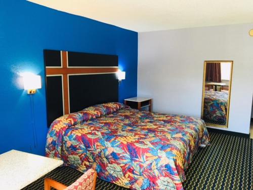 a hotel room with a bed and a cross on the wall at Fulton Inn in Atlanta