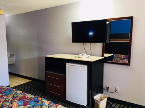 a room with a bed and a desk and a mirror at Fulton Inn in Atlanta