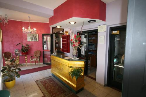 a lobby with red walls and a vase of flowers at Hotel La Meridiana in Anghiari