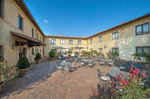 an outdoor patio with tables and chairs in a courtyard at Relais dell'Olmo in Perugia