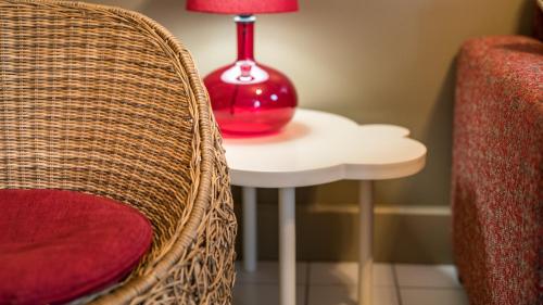 a red lamp sitting on a table next to a chair at Cottage "Les MARAIS" à quelques pas du Lac de la forêt d'Orient - Les Cottages du Belvédère in Mesnil-Saint-Père