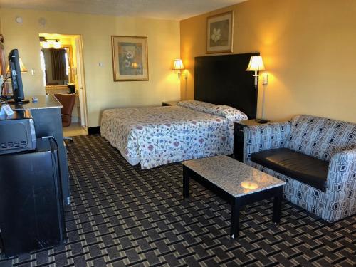 a hotel room with a bed and a couch and a tv at Knights Inn Mount Laurel in Mount Laurel