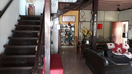 a staircase in a room with a couch and a table at Pousada Casa D` Guio in Rio das Ostras