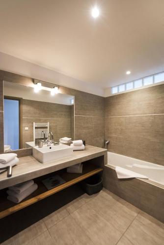 a bathroom with a large sink and a tub at Domaine Santa Giulia Palace in Porto-Vecchio