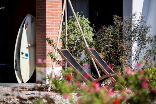 a pair of wooden folding chairs in front of a door at Hotel Balea in Guéthary
