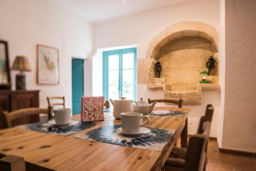 - une table en bois avec des tasses dans l'établissement Château Croix Beauséjour "Maison du Vigneron", à Montagne