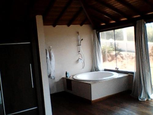 a large bathroom with a tub and a window at Villa Ferradura in Búzios