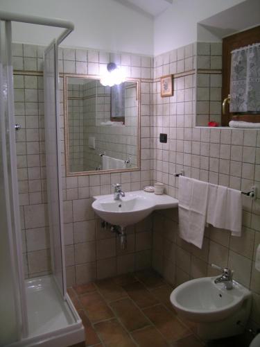 een badkamer met een wastafel, een spiegel en een bad bij Les Chalets B&B in Villetta Barrea