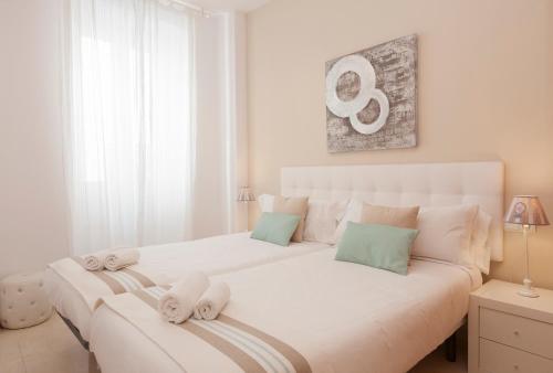 a white bedroom with two beds with towels at Blaumar in Sitges