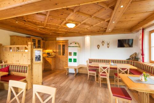 a room with wooden ceilings and tables and chairs at Hinteregghof in Forstau
