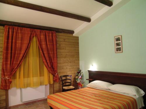 een slaapkamer met een bed en een raam bij Les Chalets B&B in Villetta Barrea