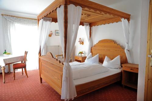 Schlafzimmer mit einem Holzbett mit Baldachin in der Unterkunft Landgasthof Zum Schwarzen Adler in Markt Nordheim