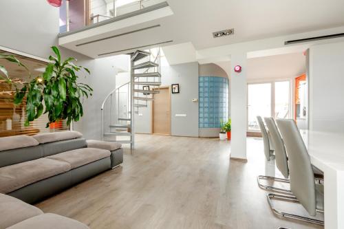 a living room with a couch and chairs and a staircase at Penthouse Apartment with Terrace in Rīga