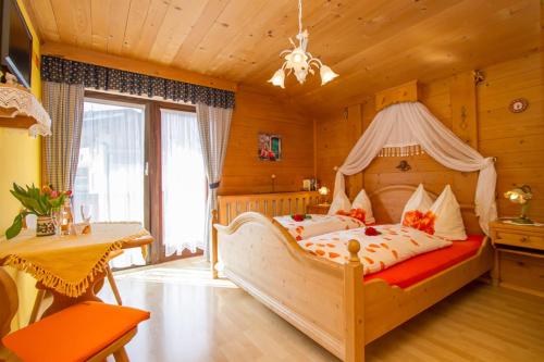 a bedroom with a large bed with a canopy at Gästehaus Neumayer in Fieberbrunn