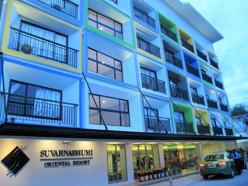 a blue building with a car parked in front of it at Suvarnabhumi Oriental Resort in Lat Krabang