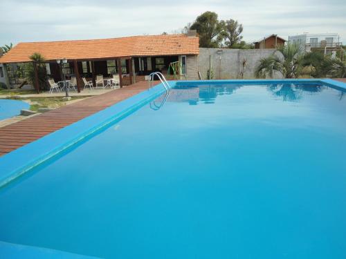 a large swimming pool in front of a house at Complejo Turistico Anaconda Hotel in La Paloma