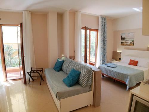 a living room with a bed and a couch at Hotel Residence Piccolo in Parghelia