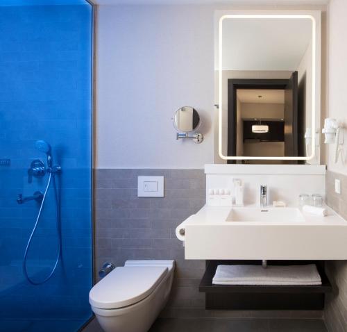 a bathroom with a sink and a toilet and a mirror at Park Inn by Radisson Istanbul Atasehir in Istanbul