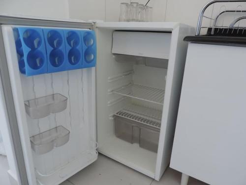 a white refrigerator with its door open in a kitchen at Meu Apê Maringá - UEM - Perto de tudo! in Maringá