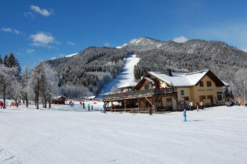 a ski lodge in the snow in front of a mountain at Berghaus Weissbriach in Weissbriach
