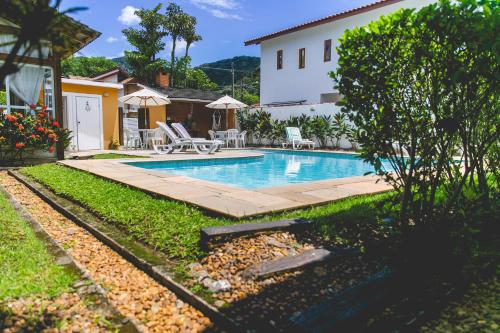 a swimming pool in the backyard of a house at Pousada Rosa dos Ventos Juquehy in Juquei