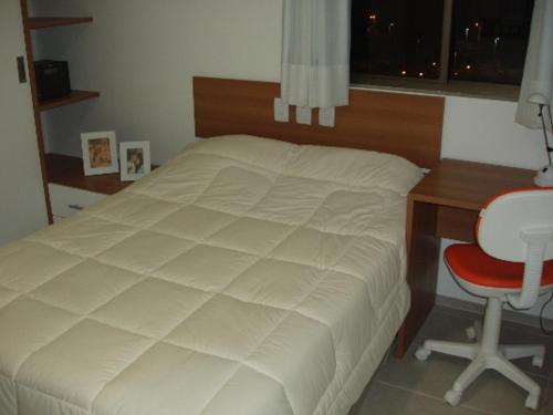 1 dormitorio con cama, escritorio y silla en Flat em Boa Viagem - Recife, en Recife