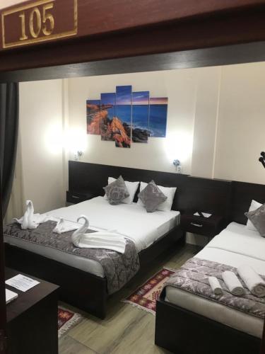 a hotel room with two beds with swans on them at Prenociste DM5 in Novi Pazar