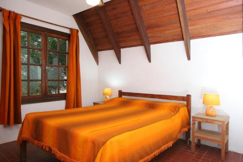 1 dormitorio con 1 cama grande de color naranja en una habitación en Complejo Turístico Anaconda Cabañas, en La Paloma