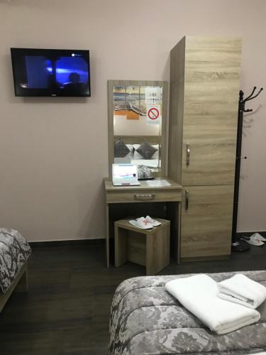 a room with a bed and a desk and a mirror at Prenociste DM5 in Novi Pazar