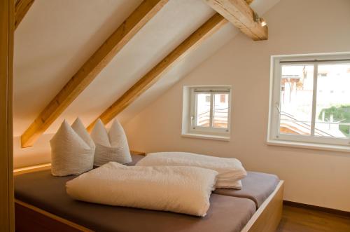 Zimmer mit einem Bett mit weißen Kissen in der Unterkunft Chasa Alpetta in Samnaun