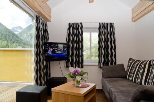ein Wohnzimmer mit Sofa und Fernseher in der Unterkunft Chasa Alpetta in Samnaun