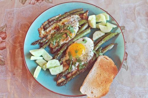 a blue plate of food with an egg and vegetables at Svajonių Dvaras in Balninkai