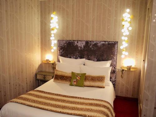 a bedroom with a bed with lights on the wall at Le Chapeau Rouge in Lusignan