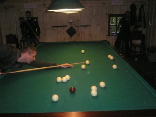 a man is playing pool on a pool table at Svajonių Dvaras in Balninkai