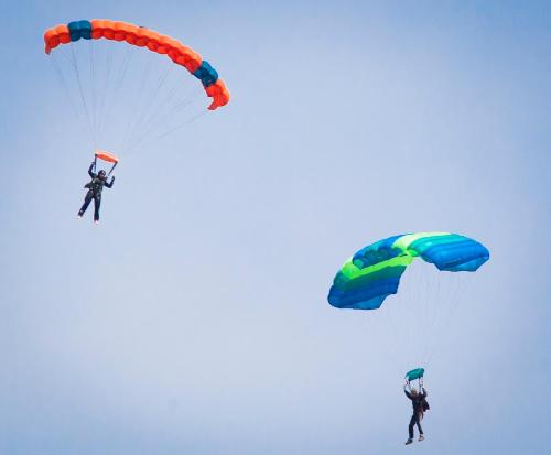 two people are flying in the sky with parachutes at Apartment/Room ''Dalmacija'' SINJ in Sinj