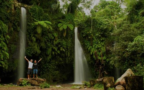 a man standing in front of a waterfall at Mu Homestay in Tetebatu