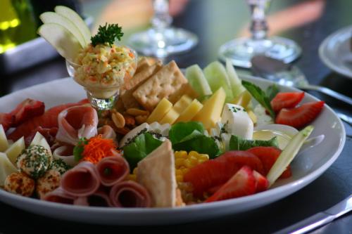 a plate of food with fruit and vegetables on a table at Hotel Presidente in Santiago