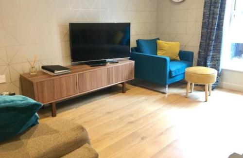 a living room with a flat screen tv and two chairs at Blue River, Parking subject to availability in York