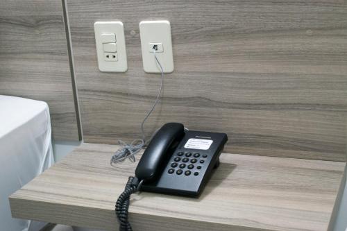 a black phone is sitting on a table at Müller Hotel in Bella Vista