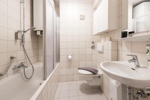 a bathroom with a sink and a toilet and a shower at Wohnen auf Zeit - Innenstadt-Appartements in Freiburg im Breisgau
