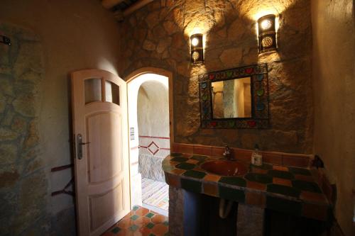 a stone bathroom with a sink and a mirror at Auberge Ibrahim in Agoudal