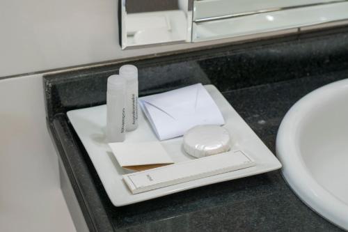 un bagno con un vassoio con articoli da toeletta e un lavandino di Müller Hotel a Bella Vista