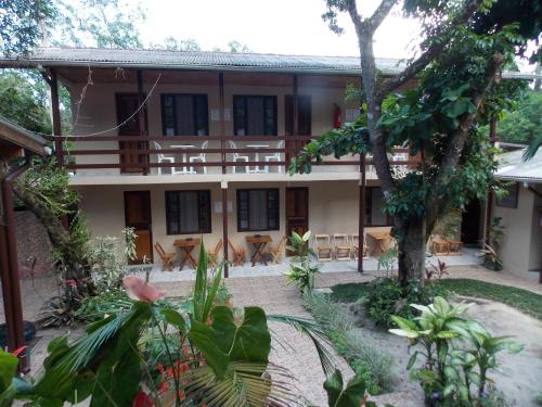 a building with tables and chairs in a courtyard at Pousada Paraíso in Ilha do Mel