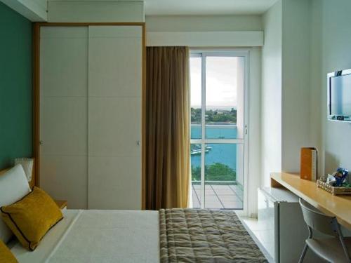 1 dormitorio con 1 cama y puerta corredera de cristal en Praia do Canto Apart Hotel, en Vitória